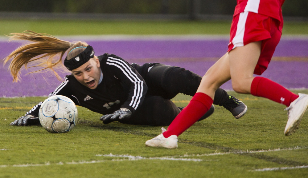 Sanford goalkeeper Kyla Bragg scrambles for the ball as a teammate runs in to boot it away if necessary Thursday during the SMAA game against Deering. Sanford used a late penalty kick to earn a 2-2 tie at Deering High and stay undefeated.