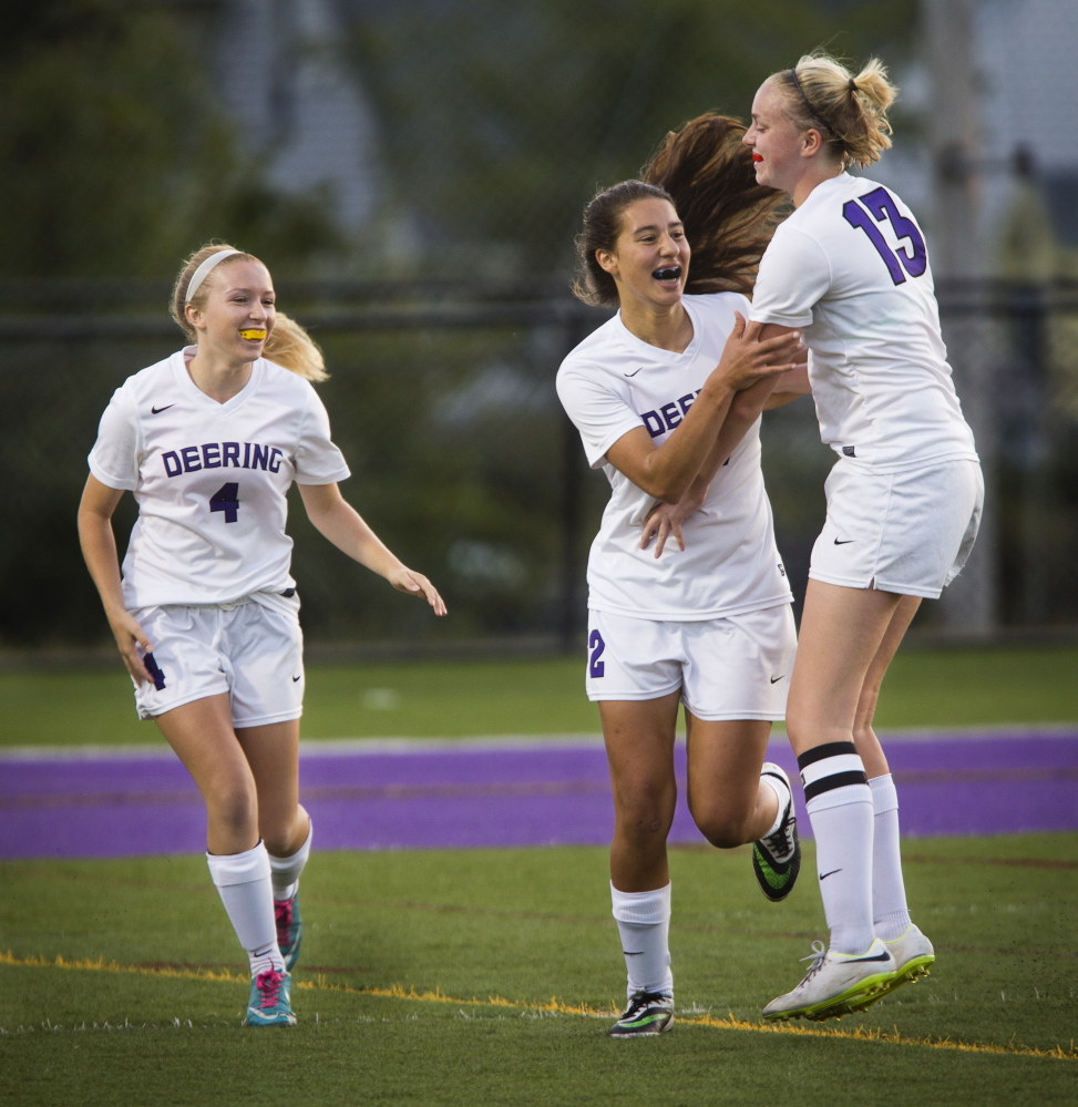 Meghana Clere, center, celebrates with teammate Cora Melcher after scoring a first-half goal against Sanford. Joining in for the Rams is Luci Santerre. Deering built a 2-0 halftime lead before Sanford rallied.