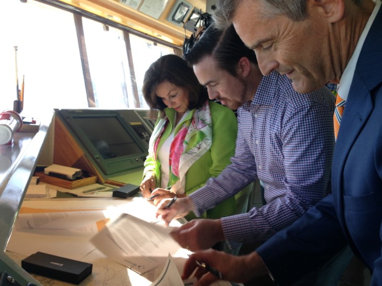 UNE President Danielle Ripich and USM President Glenn Cummings, right, sign agreements pledging their schools’ support for an effort to create a business incubator in Portland for marine-related businesses. Between them is Patrick Arnold, majority owner in the Ocean Cluster House.
Whit Richardson/Staff Writer