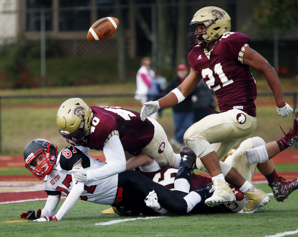 Greg Ruff of Thornton Academy keeps his eye on the football after Griffin Madden of Scarborough fumbled. Rome Pura makes the tackle.