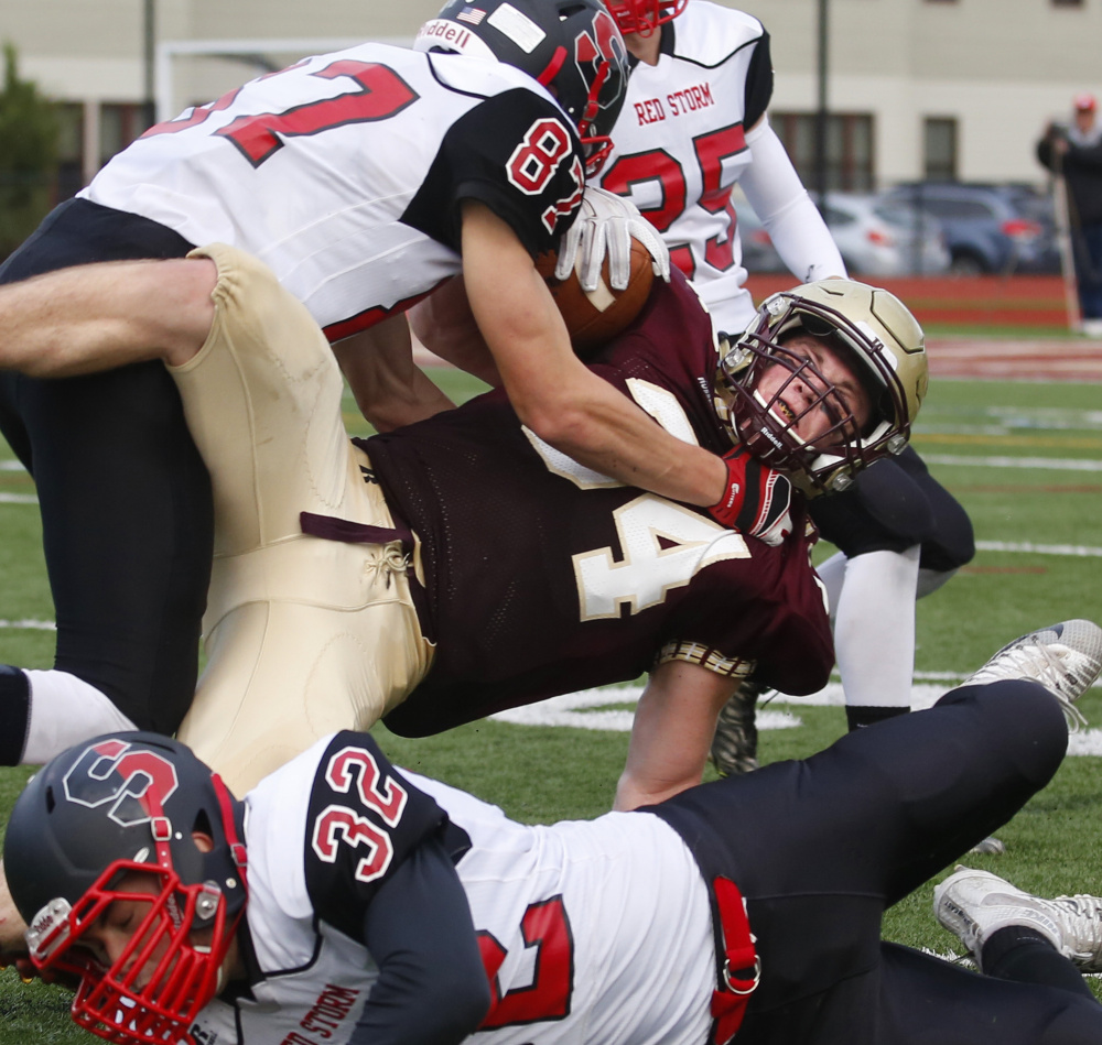 Owen Elliott of Thornton Academy finds little running room in the third quarter while being brought down by Griffin Madden of Scarborough.