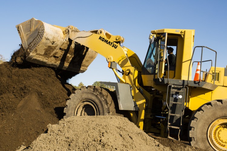 Rick Dubois of Dubois Livestock and Excavating uses a loader to stack compost-blended topsoil at the company’s farm in 2015. The odor produced by a spreading of compost at the time had prompted complaints from people in the area. Now, state regulators intend to revoke the company's licenses.