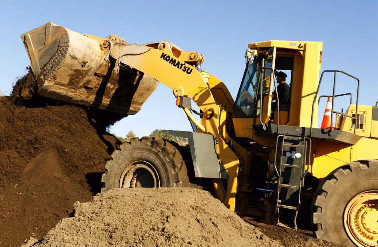 Rick Dubois, owner of Dubois Livestock & Excavating Inc., uses a loader to stack compost-blended topsoil at the company's Arundel farm on Thursday. The odor produced by a recent spreading of compost on some of their fields caused complaints from people in the area. 