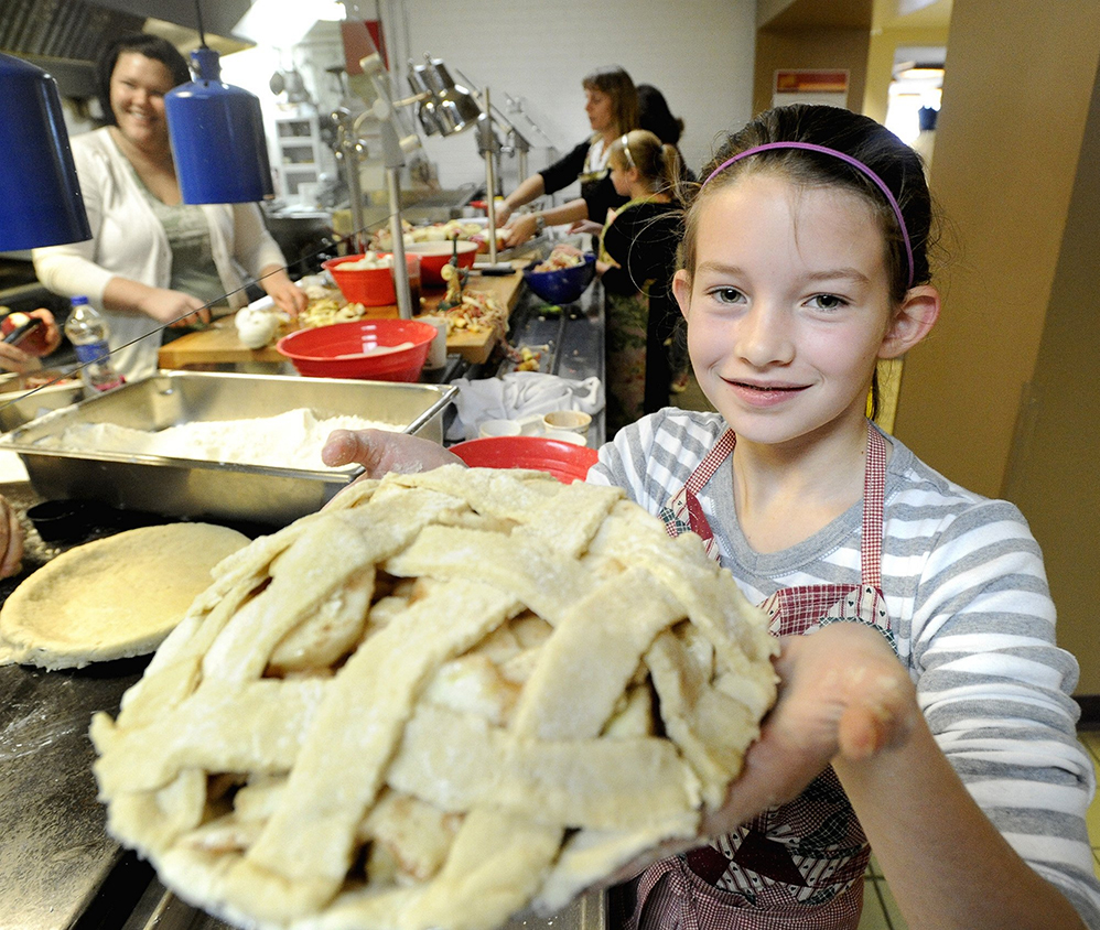 Grace Perron holds a finished apple pie at St. Joseph's College in Standish to give out at a local food pantry in November 2010.