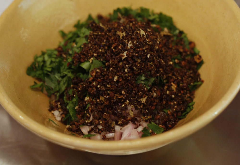 Garlic, bay leaves, juniper berries and parsley are among the flavoring agents in a rub for the raw duck legs.
