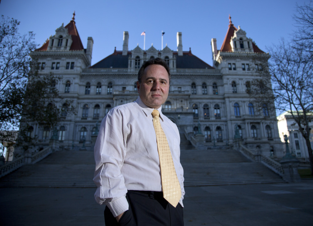 In this Nov. 23, 2015 photo, College of Saint Rose professor Bruce Roter, founder and president of the Museum of Political Corruption, poses outside the state Capitol in Albany, N.Y. Roter envisions a museum that would not only detail Albany’s many political scandals but also offer some possible solutions to corruption.  (AP Photo/Mike Groll)