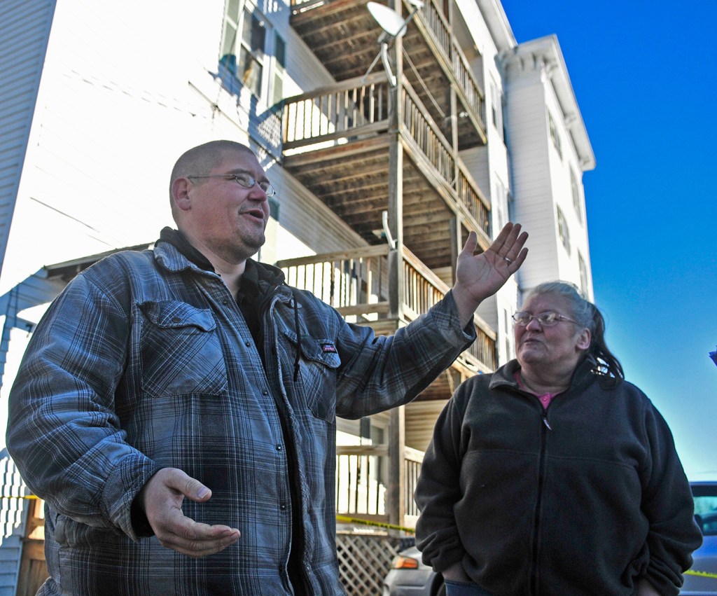 Timothy Lane Jr., standing with Cindy Clark, who is a first-floor tenant at 75 Washington St. in Augusta, called police when the light fixtures in his third-floor apartment started shaking because of the thudding in the apartment above.