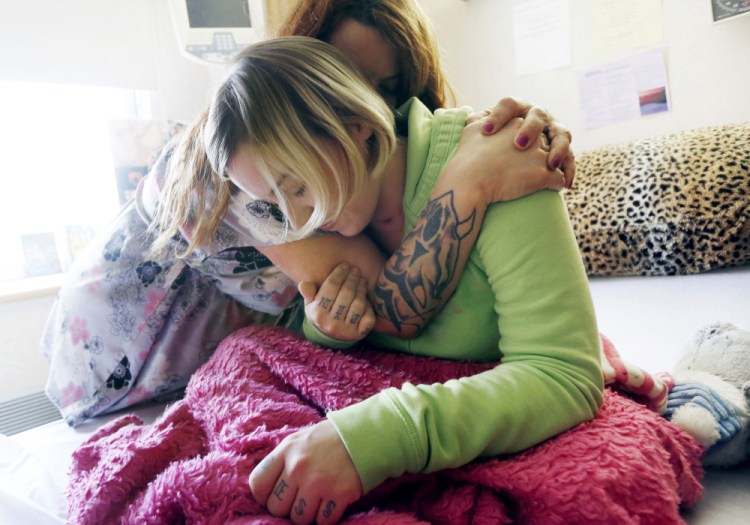 Taylor Norcross gets a hug from her mother, Page Masse-Brown, at Central Maine Medical Center in Lewiston. Doctors say Norcross, who left the hospital in December, is recovering unusually quickly after being critically injured in a car-moose collision.