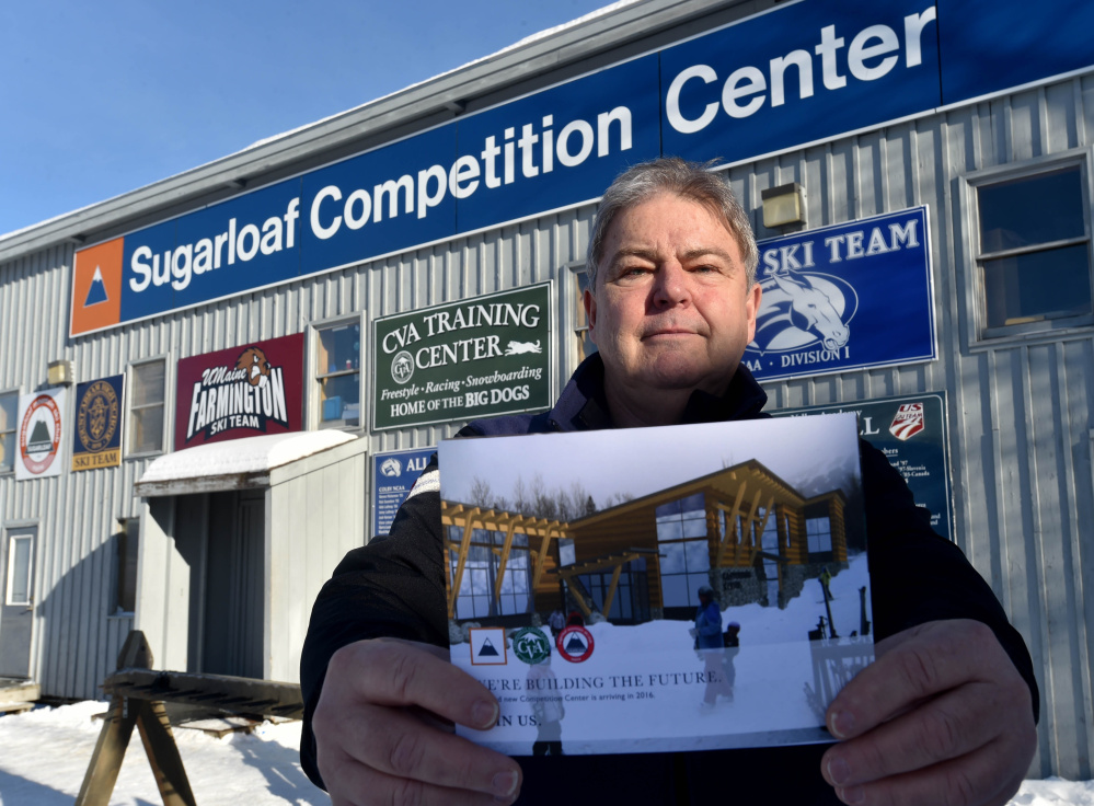 Bruce Miles, president of the Sugarloaf Ski Club, holds a rendering of a proposed Competition Center while standing in front of the existing competition center.