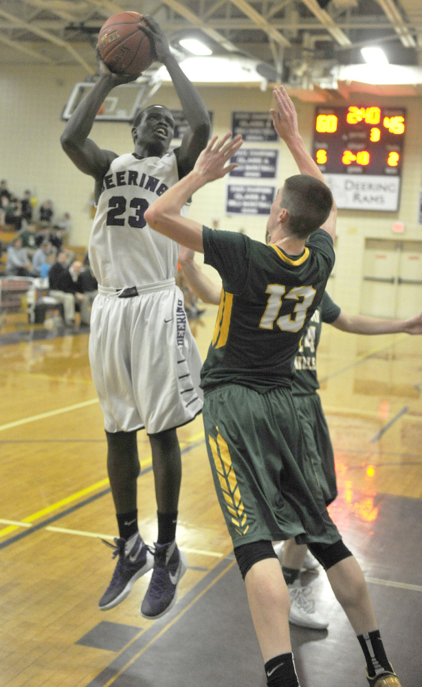 Deering’s Anthony Lobor goes up for a shot over Oxford Hills’ Matt Fleming during the Rams’ 81-59 win on Monday. Lobor scored 18 points and the Rams rebounded from their first loss of the season to improve to 11-1.