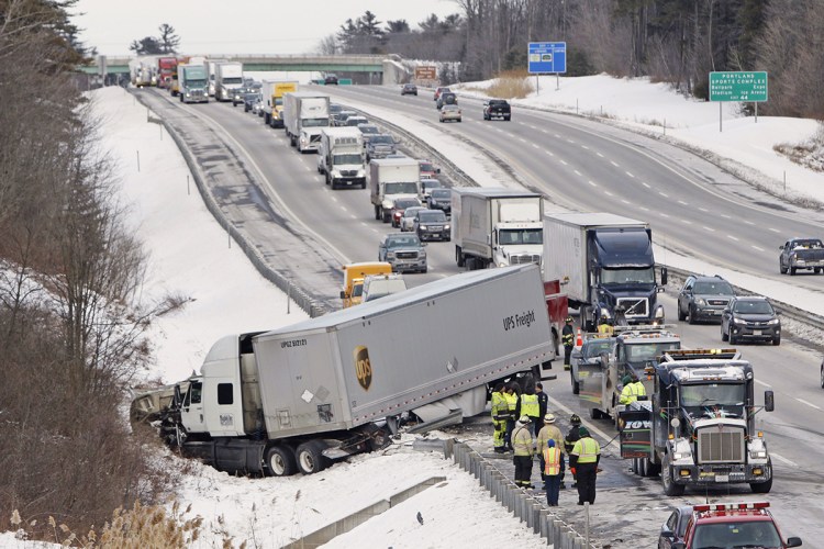 The tractor portion of a UPS truck is buried in the snow in a ditch alongside the Maine Turnpike in Scarborough on Tuesday. Gregory Rec / Staff Photographer