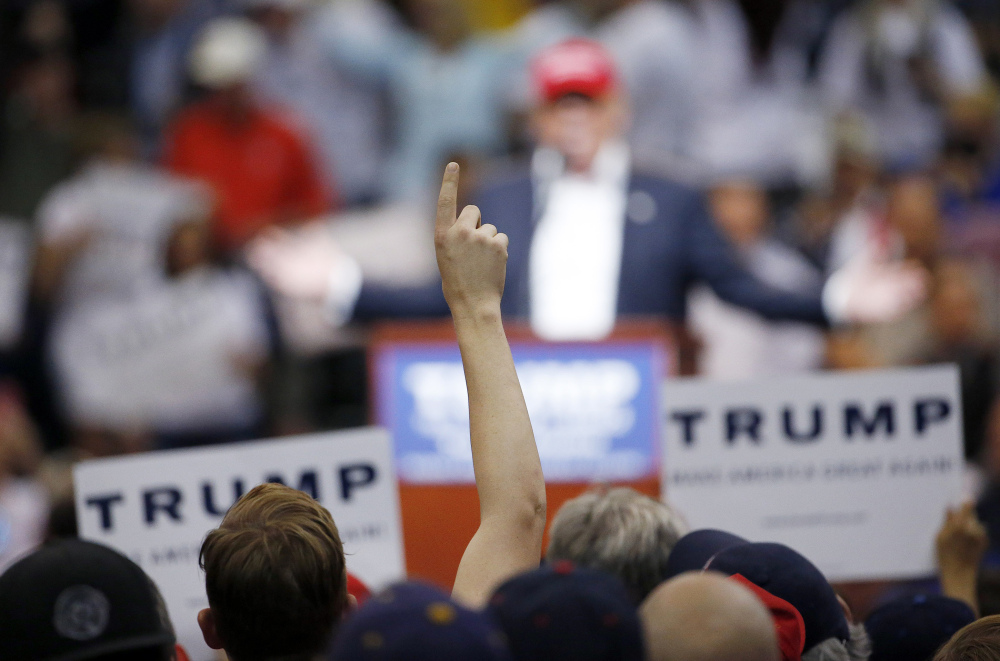 A Donald Trump supporter holds up his finger as he listens to the Republican presidential candidate speak during a campaign rally Saturday in Tucson, Ariz.