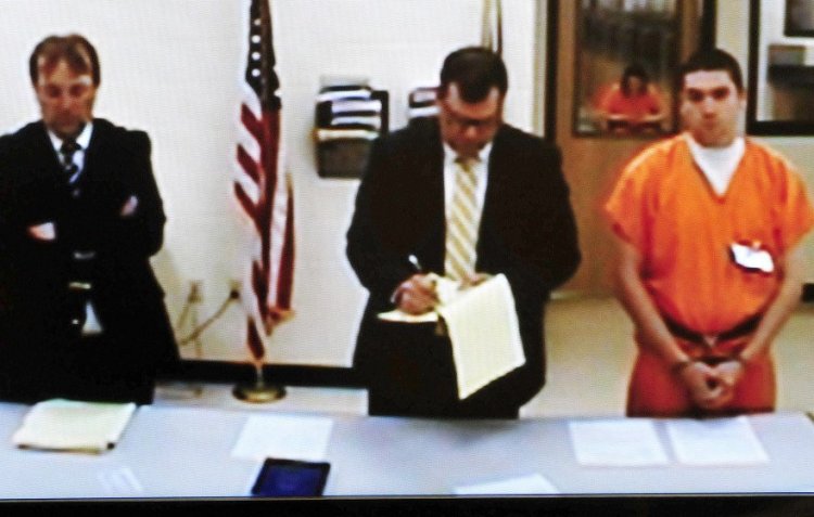 Jeremy Erving, right, listens via video in Skowhegan District Court on Monday. At left is Assistant District Attorney Brent Davis and attorney John Martin is at center. Erving is being held without bail on charges he killed his uncle Randy Erving in St. Albans last week. David Leaming/Staff Photographer