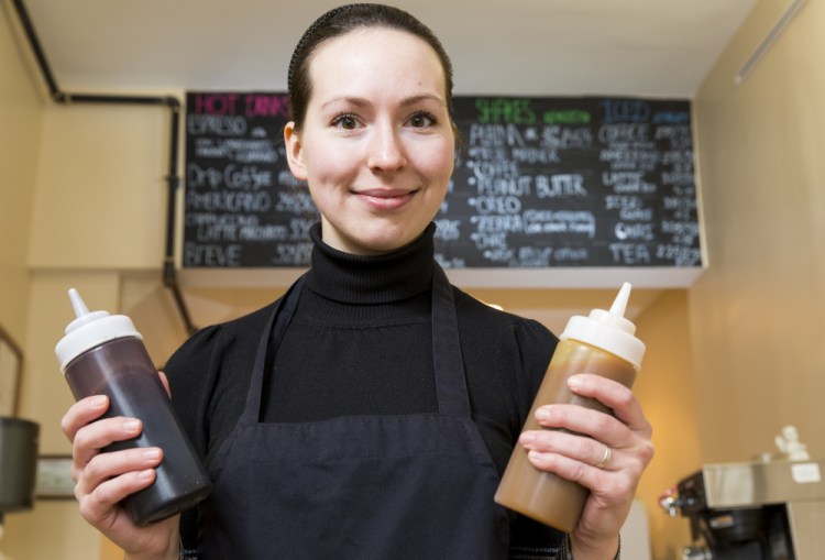 Yulia Stolkner hoists squeeze bottles of chocolate and caramel at her newly opened cafe Sip of Europe at 229 Congress St.