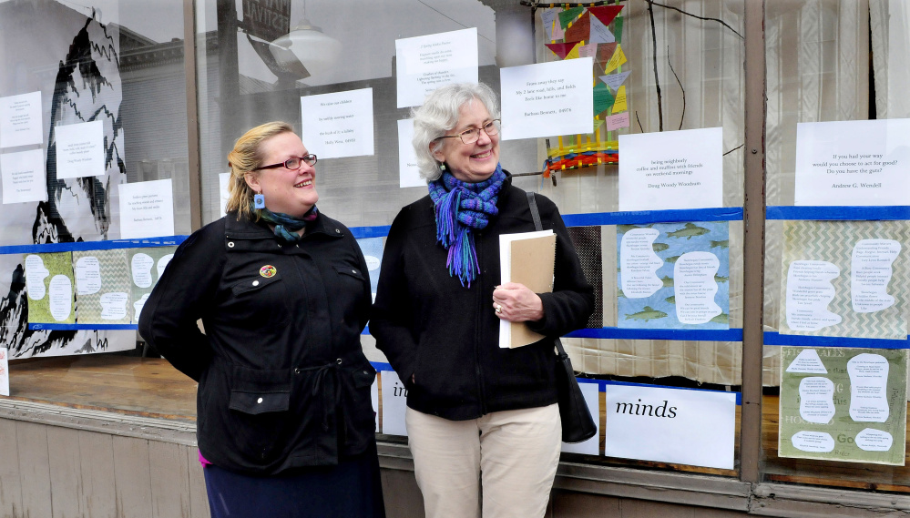 Serena Sanborn, left, and Nina Pleasants speak about the haiku poems and artwork on the front window of the former Variety Drug store in Skowhegan on Monday. The Wesserunsett Arts Council is sponsoring Japanese haiku poems all over Skowhegan as part of poetry month.