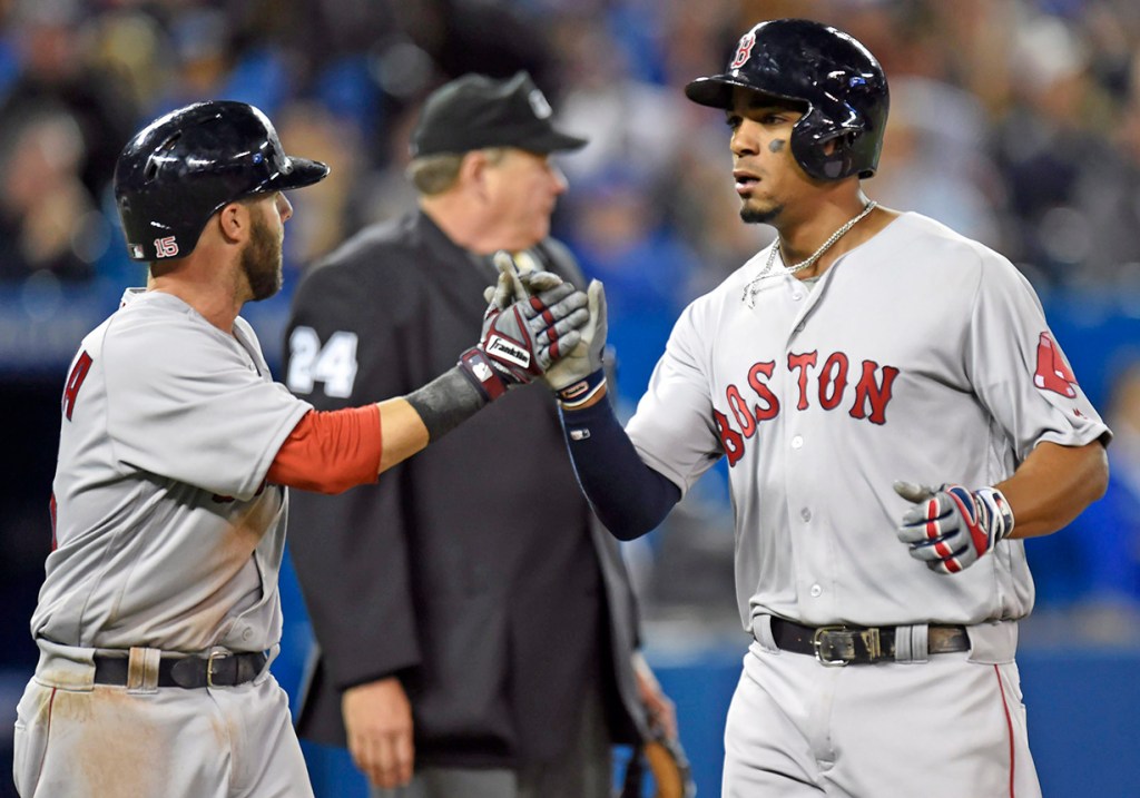 Boston Red Sox' Dustin Pedroia congratulates teammate Xander Bogaerts after scoring during the fifth inning Saturday. Frank Gunn/The Canadian Press via AP