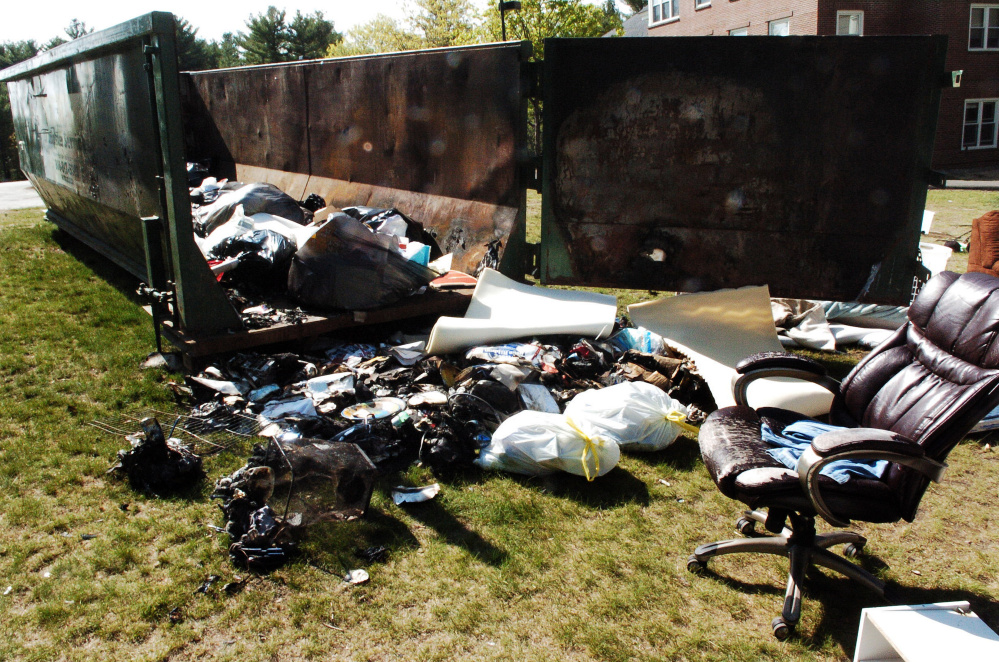 Furniture and other items that were burned last weekend damaged a Dumpster outside the Alfond dormitory on the Colby College campus in Waterville.