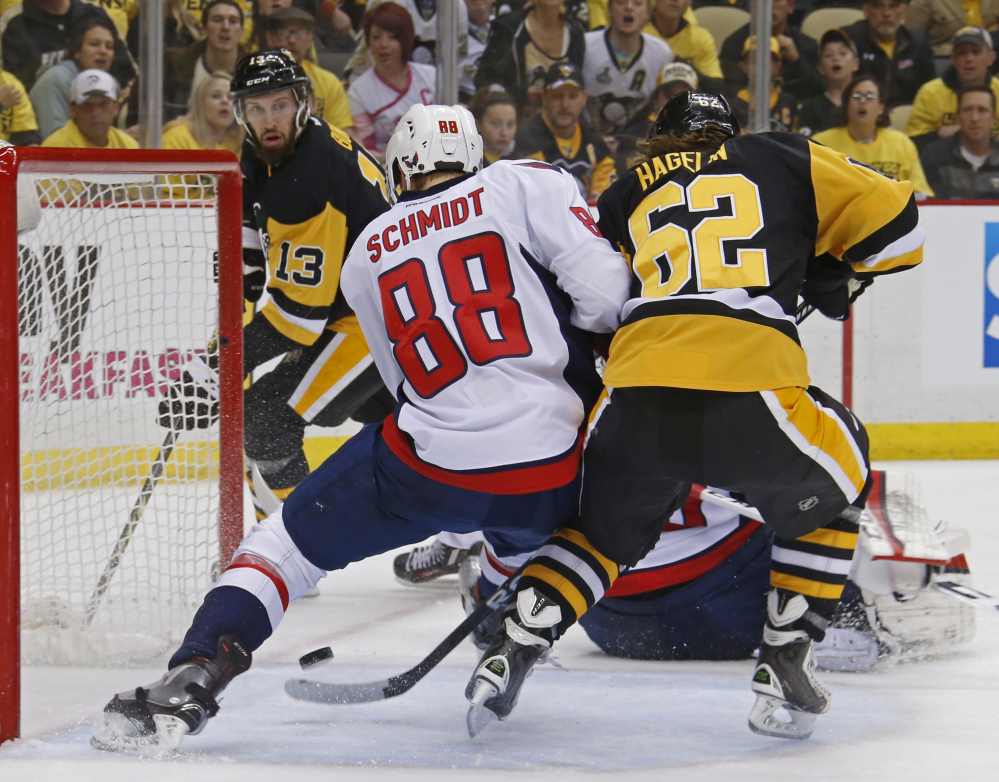 Pittsburgh's Carl Hagelin, right, deflects the puck past Washington's Nate Schmidt for a second-period goal during the Penguins' 3-2 playoff win Monday at Pittsburgh.