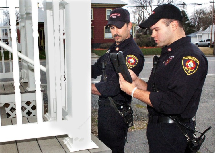 Skowhegan Fire Capt. Jason Frost, left, measures a stairway as firefighter Scott Libby records data using an iPad on Wednesday at an apartment building in Skowhegan. The inspections are offered to landlords to make them aware of safety issues and to remedy problems.