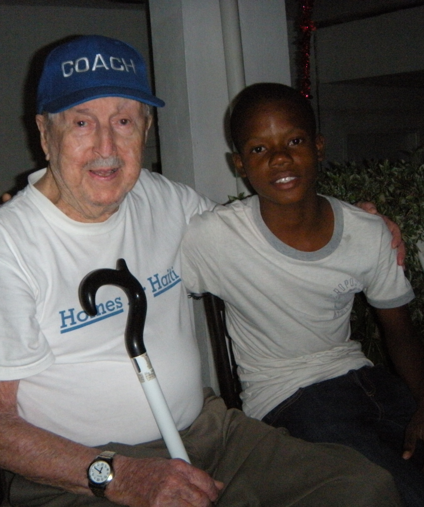 Maykerlens Lovitz "Lolo" Romain, right, is finishing elementary school at St. Patrick Youth Center, built in Haiti by Coleman "Coley" Gorham, left, and his wife, Anna Gorham.