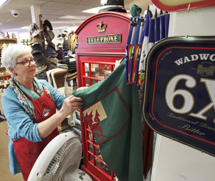 Karen Bussey straightens up at Bridgham & Cook in Freeport. The store imports goods from Britain, but owners say they might not benefit from a lower exchange rate in the long run.