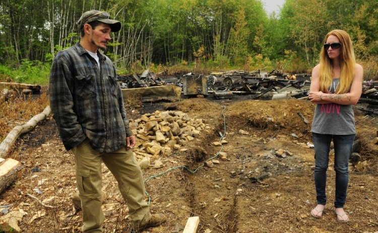 Fire victims Eric and Kristie Baker stand on their property in Gardiner last week after a fire destroyed their camper. Police arrested Joseph Manganella, 35, of Gardiner on Friday a charge of arson related to the case. 