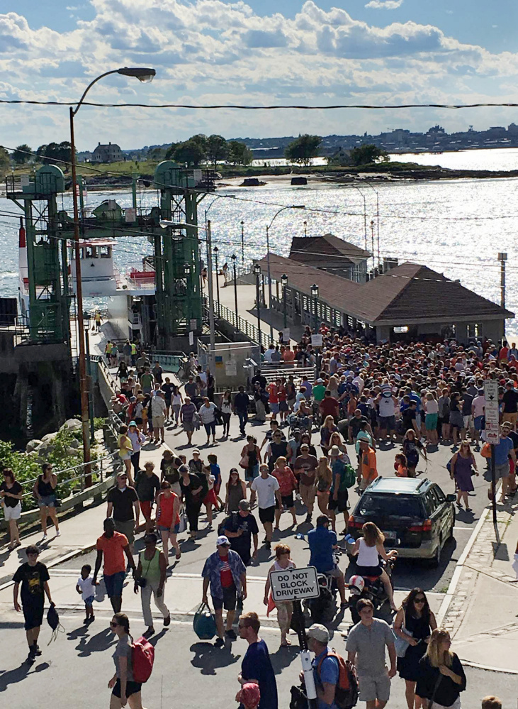 Passengers stream from the ferry landing July 3 on Peaks Island. Recent heavy use of the ferry has some islanders thinking Peaks residents should get boarding priority.