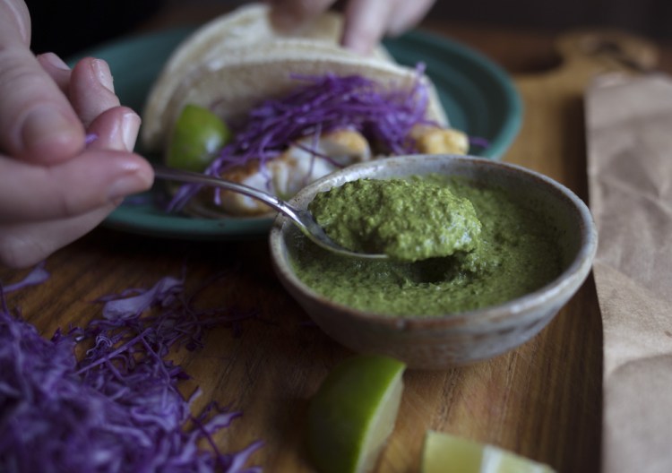 Christine Burns Rudalevige scoops cilantro-and-corn pesto onto fish tacos.