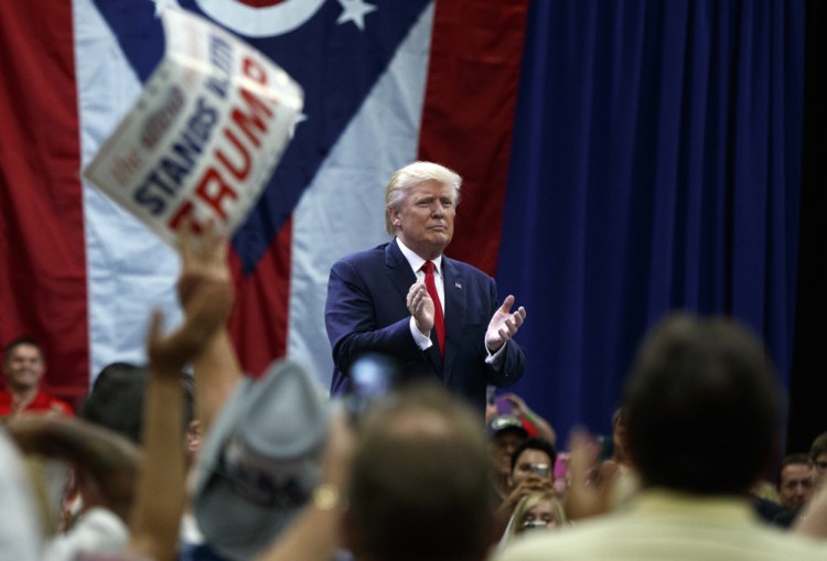 Republican presidential candidate Donald Trump applauds after speaking during a town hall event Monday in Columbus, Ohio.