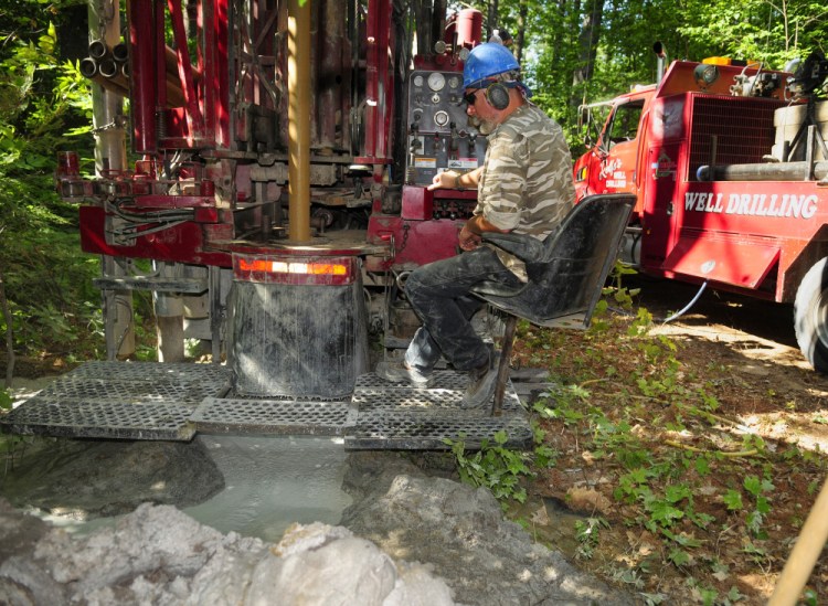 Fred Rolfe mans the controls as the crew from Rolfe's Well Drilling drills a well this month at a home construction site in Belgrade. Many homeowners replaced dug wells with drilled wells following the last drought, and most new construction since then relies on drilled wells.