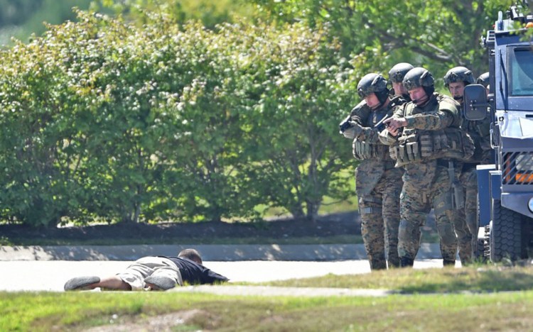 Troopers with the Maine State Police tactical team and Somerset County sheriff's deputies take into custody an armed man, who police say was threatening suicide, after a two-hour standoff in the parking lot at Wal-Mart in Palmyra on Friday. 