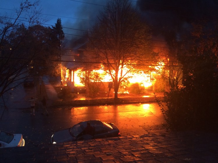 Flames engulf the building at 20-24 Noyes St. shortly after 7 a.m. on Nov. 1, 2014. The cause of the fire was found to be a discarded cigarette that ignited materials on the front porch.