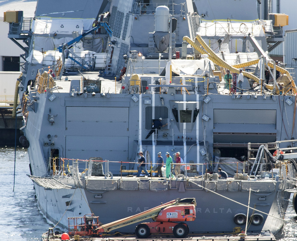 Shipbuilders walk across the aft deck of an Arleigh Burke destroyer that's currently under construction at Bath Iron Works in Bath. More than 6,000 workers are employed here, the yard's highest level in more than a decade, but losing a lucrative cutter contract is expected to reduce that number in time.