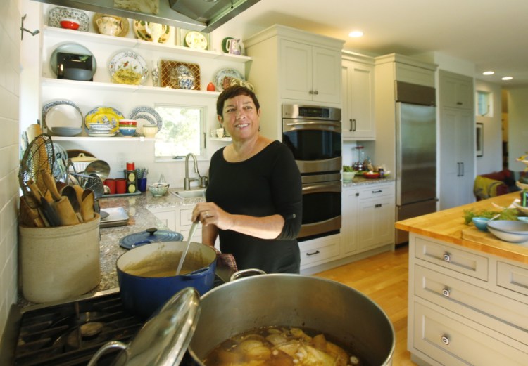 Kathy Gunst stirs the soup in the kitchen of her South Berwick home. Her new cookbook,  "Soup Swap," below, grew out of a monthly community soup swap that she and her husband attend. "I really don't like potlucks," she says, but with the soup swap, "you go home with more than you bring. It's a total win-win."