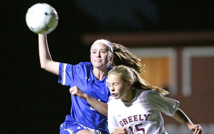 Katherine Clancy of Greely heads the ball away from Lily Wolff of Kennebunk in the first half. Greely improved to 8-3 with the win.   Derek Davis/Staff Photographer