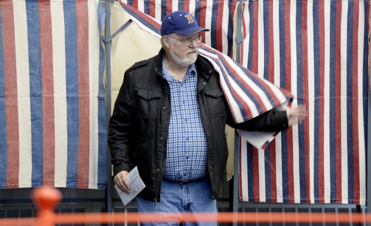 Greg Rowe of Saco leaves a booth Tuesday after voting at Saco City Hall. Mainers must provide identification when they register to vote, but do not have to show ID when casting their ballots. Gov. Paul LePage wants the state to issue voter ID cards to prevent election fraud.