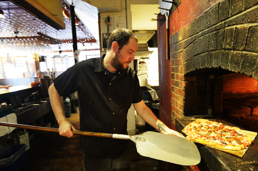 Jon Cogswell, a chef at Bonobo in Portland, takes a pizza out of the brick oven on Nov. 2.