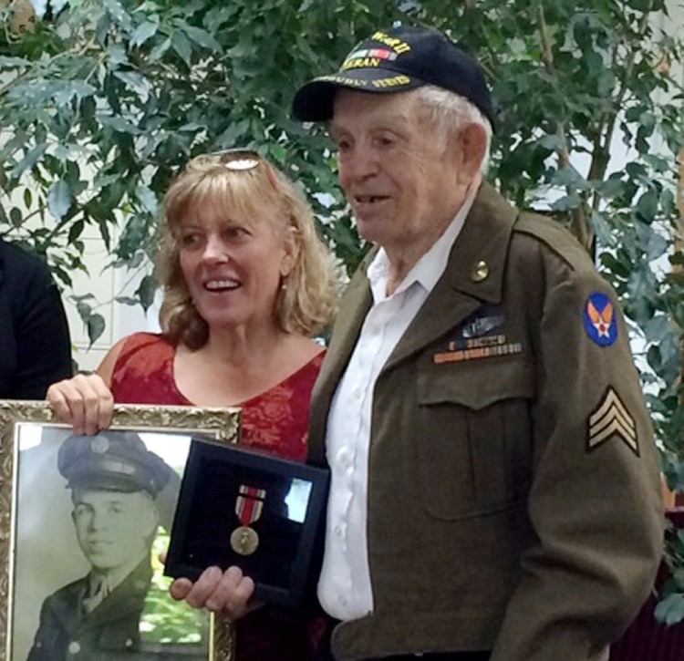 William Schnorr receives his Victory Medal at Sen. Angus King's Augusta office.