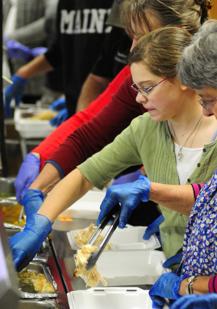 Volunteers at Gardiner Area High School serve up traditional Thanksgiving meals that were delivered Thursday to area residents.