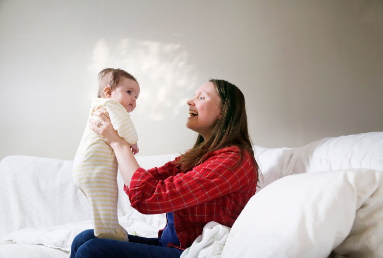 Sam Sharff of Yarmouth plays with her 3-month-old daughter, Evelyn, on Tuesday. Sam is nervous about the subject of politics being raised at Thanksgiving dinner at her father's house, but says Evelyn, his first and only grandchild, is a pretty good distraction.
Derek Davis/Staff Photographer