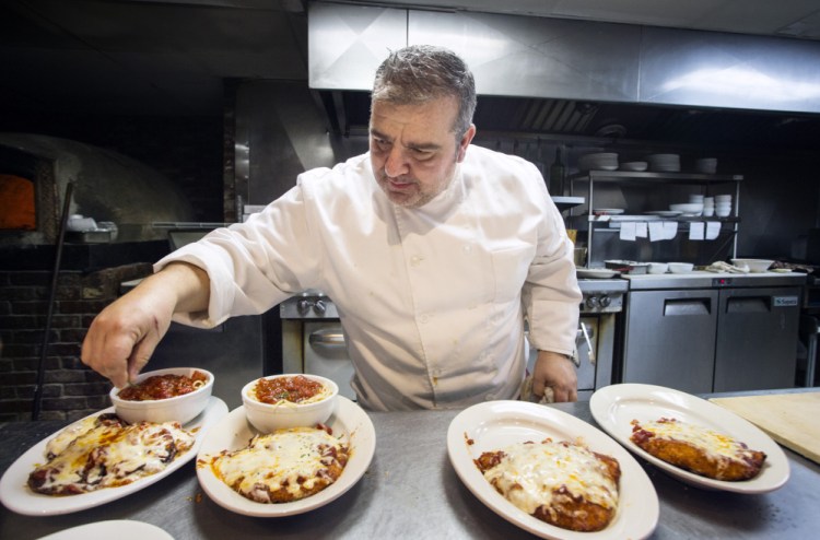 Chef and owner Redi Dede garnishes plates for serving.