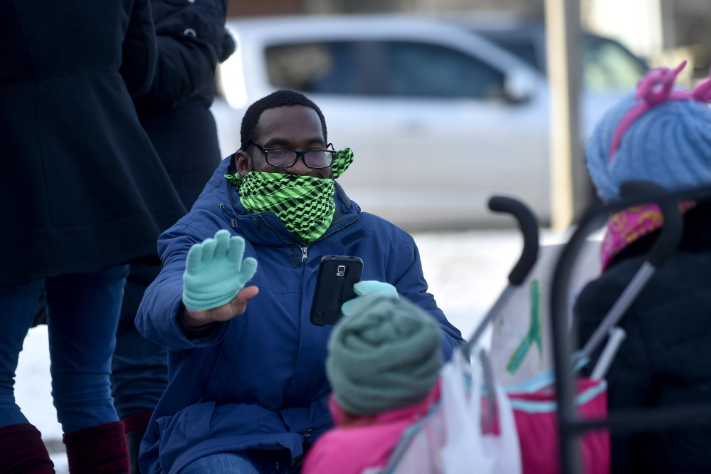 Cecil Brooks, facing, waves to a fellow Forward Together marcher at Post Office Square in Waterville on Saturday.