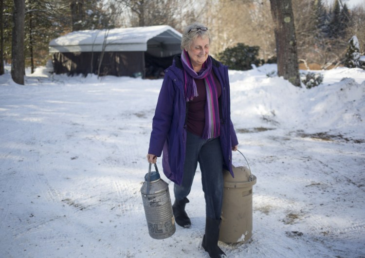 Carolyn Woerter carries containers for her bull semen business to her truck in Freeport. She takes the product all around the state, for both dairy cow and beef breeding.