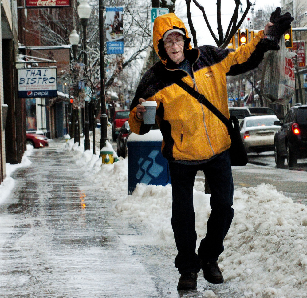 Terrence Gill regains his balance after nearly slipping on the sheet of ice covering sidewalks in downtown Waterville on Sunday morning.