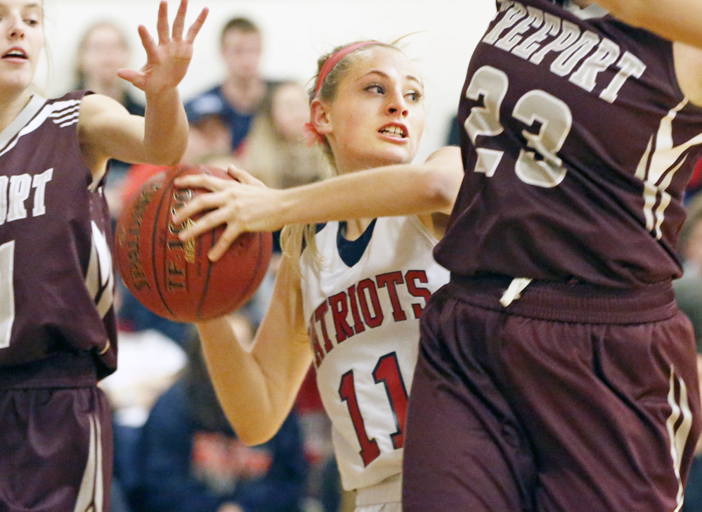 Gray-New Gloucester freshman Annika Thomas searches for an open teammate as the defense closes in for Freeport in their Western Maine Conference girls' basketball game.