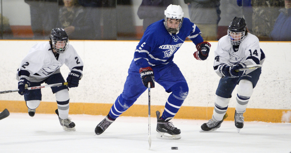 Kennebunk's Jakub Simikak is chased by Joe Truesdale, left, and Spencer King of Yarmouth during a Class B South boys' hockey game Saturday in Yarmouth. Kennebunk won in overtime, 5-4.