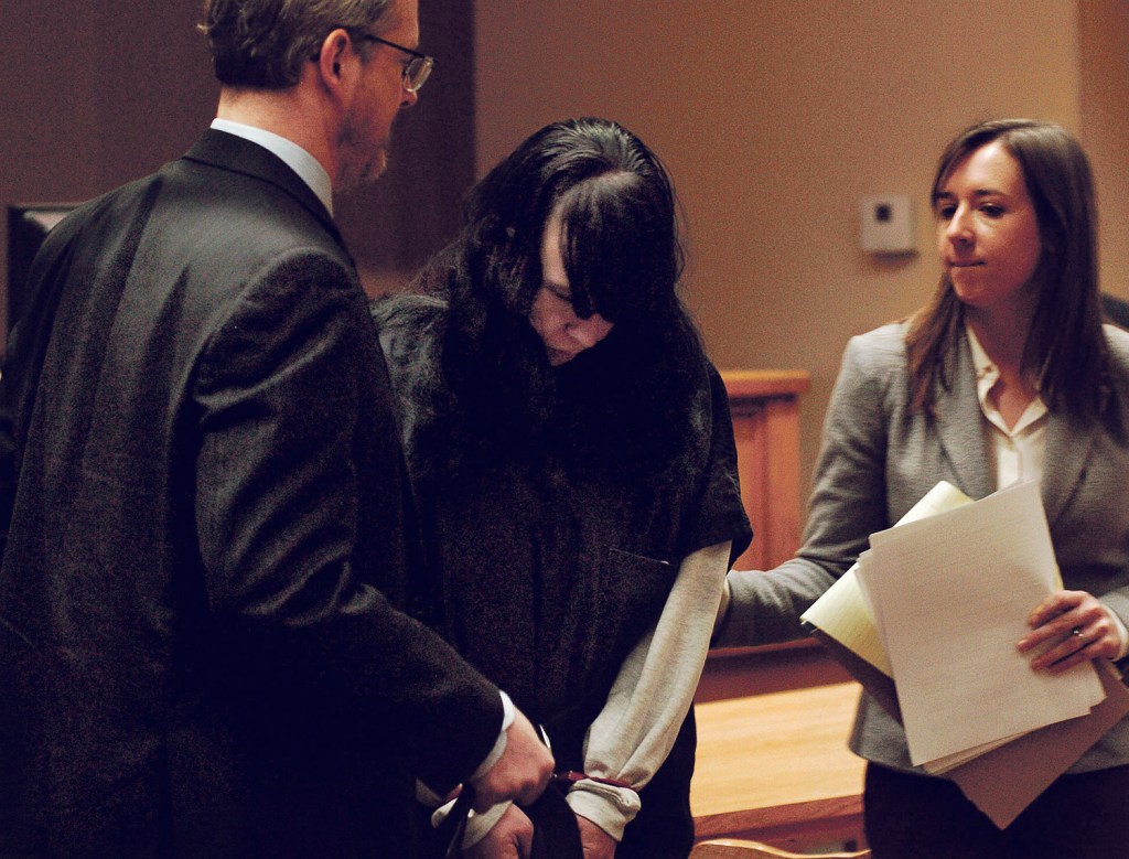 Miranda Hopkins is flanked by defense attorneys in District Court in Belfast on Tuesday after her initial appearance on a murder charge.