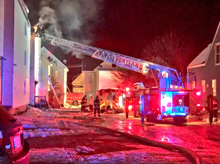 Firefighters extinguish a blaze at an apartment building on Munjoy Hill in Portland on Monday night.