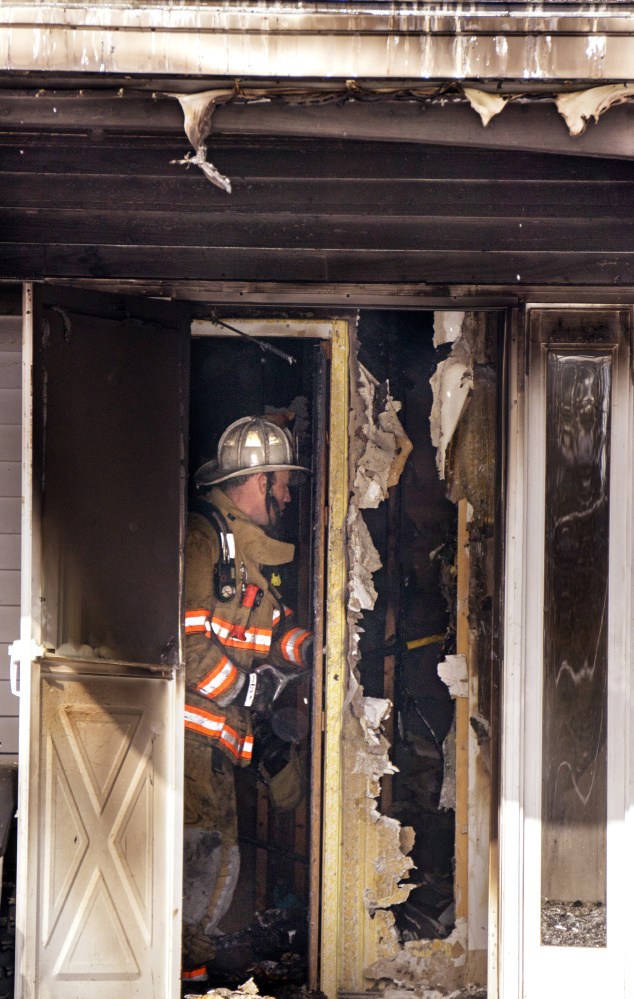 Nick Marique, fire chief with Milton (N.H.) Fire Rescue, checks for hot spots in a wall near the entry to the home at 62 Gray Birch Lane in Lebanon on Wednesday. Chief Dan Meehan of Lebanon Fire and Rescue said the fire appeared to be accidental. The private road to the house was iced over, which made it somewhat hard to access the scene. No one was injured in the fire, but a dog died. Firefighters from North Berwick, Acton, Sanford, Alfred, and Milton and Somersworth, New Hampshire, provided assistance.