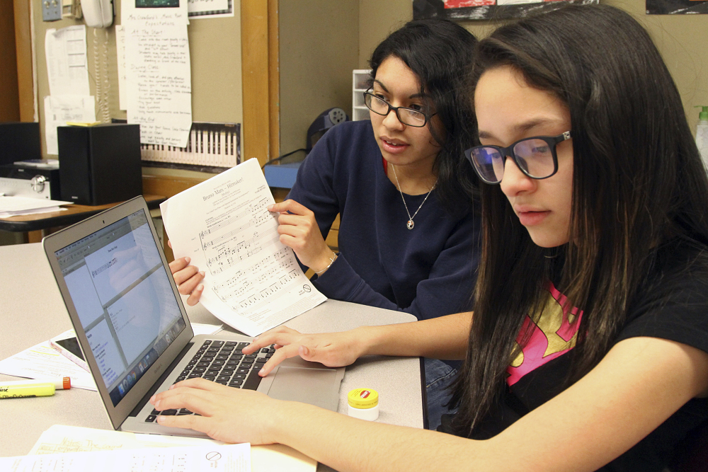 UMass Lowell student Mirza Gracia, left, and Lowell's Bartlett Community Partnership School student Hazel Rivera work on music last month.